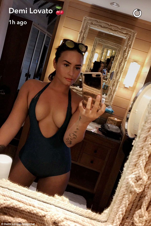 Demi Lovato slips into yet another plunging swimsuit as she shows off her curvaceous figure