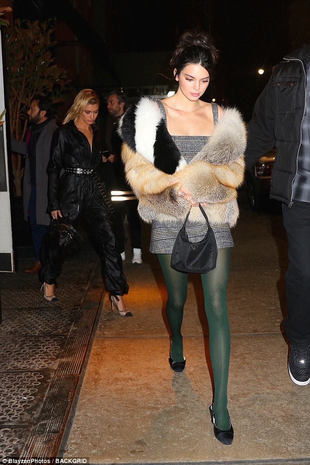 Nineties inspired! Kendall Jenner pairs plaid mini dress with green tights and a colorful fur coat